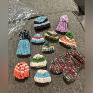 Bag of hand knitted miniature (doll size) hats and one pair of socks.  Total 11